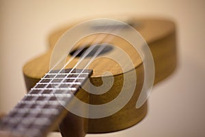 Little guitar. Ukulele made of wood. Musical instrument for extracting sounds. String instrument with fretboard and deck