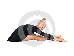 Little gymnast stretching on the floor