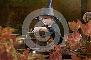 Little halloween witch with smoking cauldron