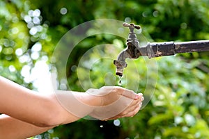 Little hand wait for water drop from faucet