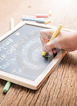 Little hand writing on a chalkboard