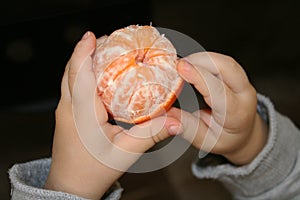 Little hands clean mandarin to have a snack