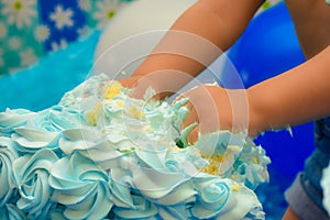 Little hands smashing cake in birthday