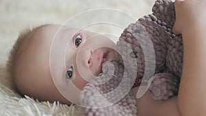 Little handsome boy hugs a plush rabbit at home, indoor. Little baby boy playing with toy.