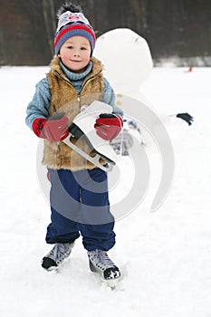 Little handsome boy with skate stands near upside photo