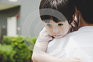 Little handsome Child hug Father during dad carry him and taking son go home after school Young boy get infect virus of flu, sick photo