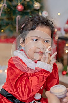 Little happy Asian girl make up and have fun on Christmas party in the living room with decoration