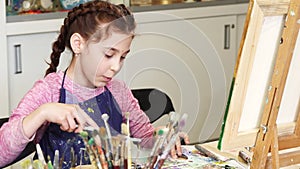 Little happy beautiful girl smiling to the camera at the art studio