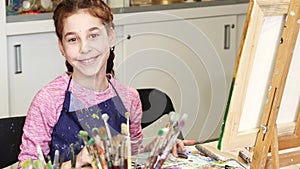 Little happy beautiful girl smiling to the camera at the art studio
