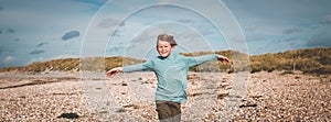 Little happy boy with a big smile on his face. Beautiful landscape and bright beach. Kid on summer autumn vacation. text