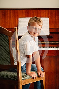 Little happy boy plays piano