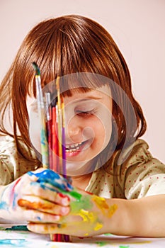 Little happy child girl painting with a brushes. Art, creativity, beauty childhood concept