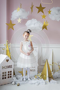 Little happy fairy or angel with magic wand on Holiday theme. Portrait of pretty caucasian little angel wearing white