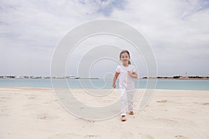 Little happy girl on the beach