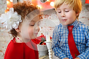 Little happy girl and boy blow out white candle, photo
