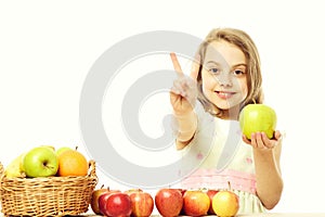 Little happy girl or cute hungry child eating colorful fruit