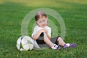 Little happy girl on football field