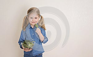 Pequeno chica feliz posesión un tazón hierbas mezclar ensalada comer una carta de un nino espinaca 