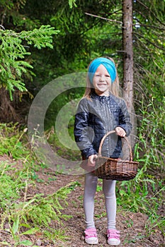 Little happy girl pick up mushrooms in autumn