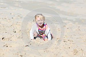 Little happy girl playing on the beach