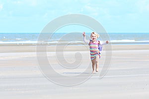 Little happy girl playing on the beach