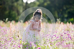 Little happy girl in a purple flower field