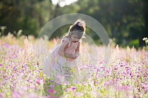 Little happy girl in a purple flower field