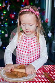 Little happy girl with rolling pin baking