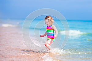 Little happy girl running on a beach