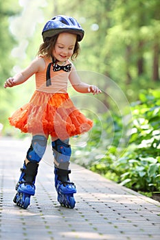 Little happy girl in skirt and helmet roller