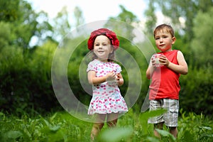 Little happy girl in wreath and boy hold milk in