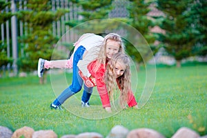 Little happy girls have a lot of fun outdoors in the park