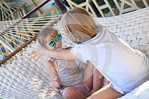 Little happy girls playing on hammock in summer day