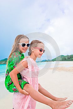 Little happy kids have a lot of fun at tropical beach playing together