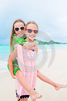 Little happy kids have a lot of fun at tropical beach playing together