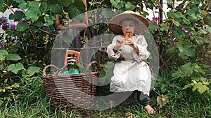 Little happy Ñountry child learning to play tin wistle, having fun and laughing. Cute boy sitting in garden and smiling