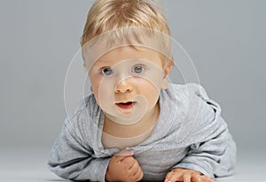 Little, happy and smiling cute baby in the studio. Portrait of a one year old baby. The concept of happiness.