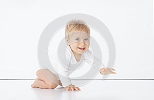 Little, happy and smiling cute baby in the studio. Portrait of a one year old baby. The concept of happiness.