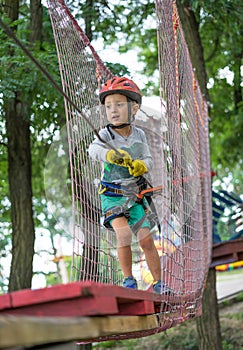 A little happy and smiling rock climber tie a knot on a rope. A person is preparing for the ascent. The child learns to tie a knot