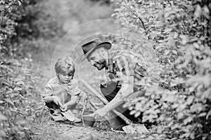 Little helper in garden. Farm family. Little boy and father in nature background. Gardening tools. Gardening hobby. Dad