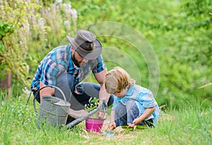 Little helper in garden. Make planet greener. Growing plants. Take care of plants. Day of earth. Boy and father in photo