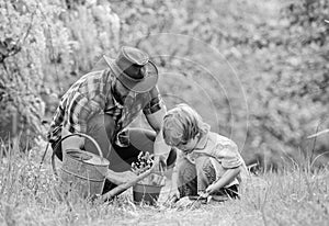 Little helper in garden. Make planet greener. Growing plants. Take care of plants. Day of earth. Boy and father in