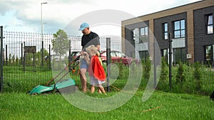 Little helper super girl daughter mow lawn with her father in townhouse yard