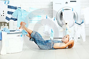 little helper tired child girl to wash clothes and rest in laundry photo