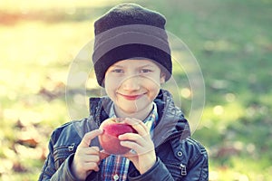Little hipster schoolboy holding apple