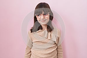 Little hispanic girl wearing glasses looking away to side with smile on face, natural expression