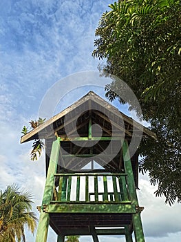 a little hut under the scorching sun and trees