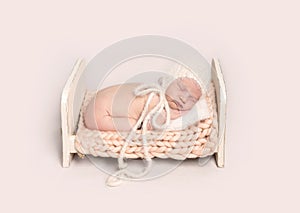 Little infant baby sleeping on tummy on wooden crib