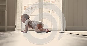 Little infant crawls on warm floor in room