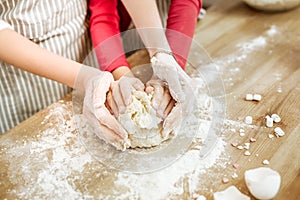 Little interested child gently hugging piece of unready dough photo